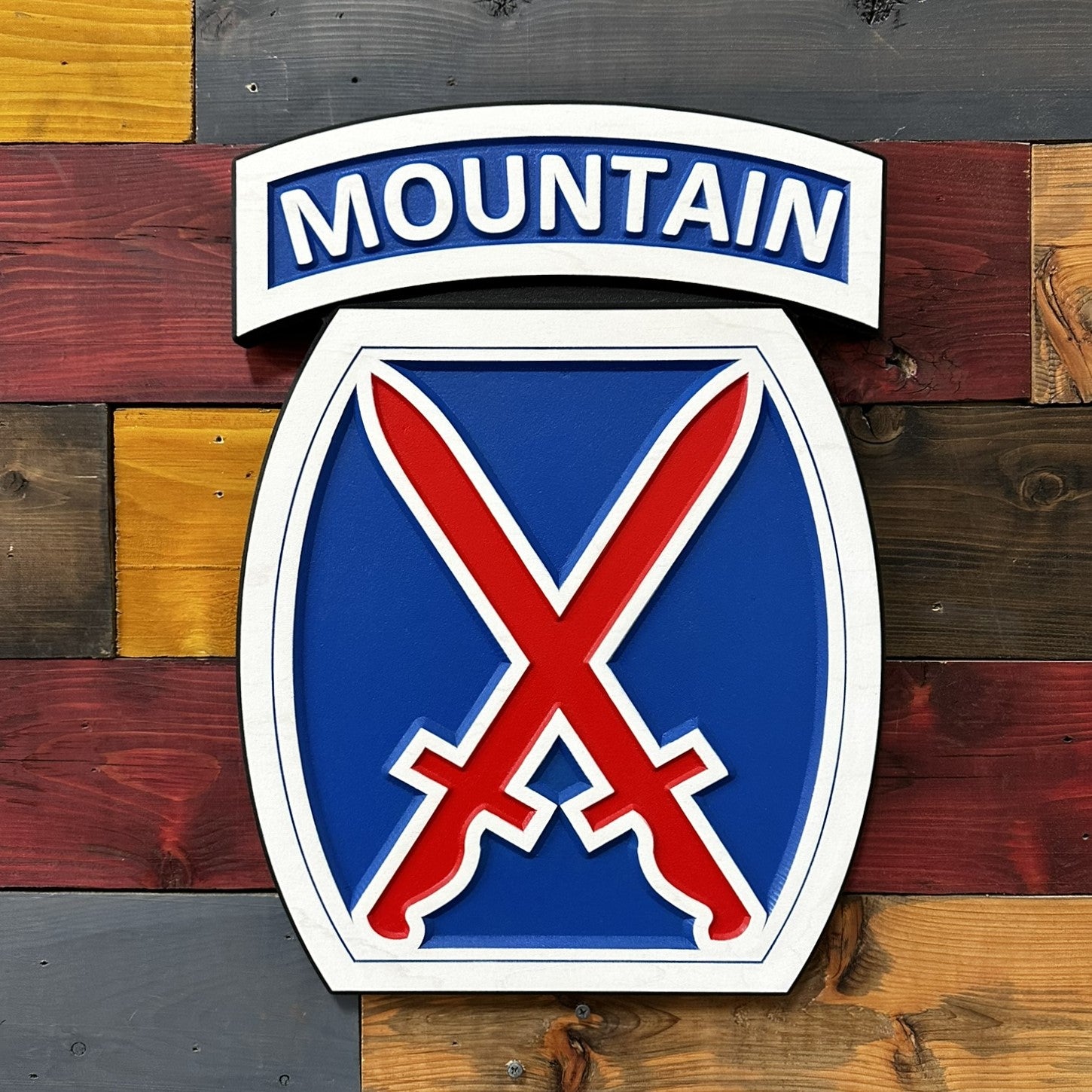 close up detail of 10th Mountain Division crossed swords insignia carved wood sign