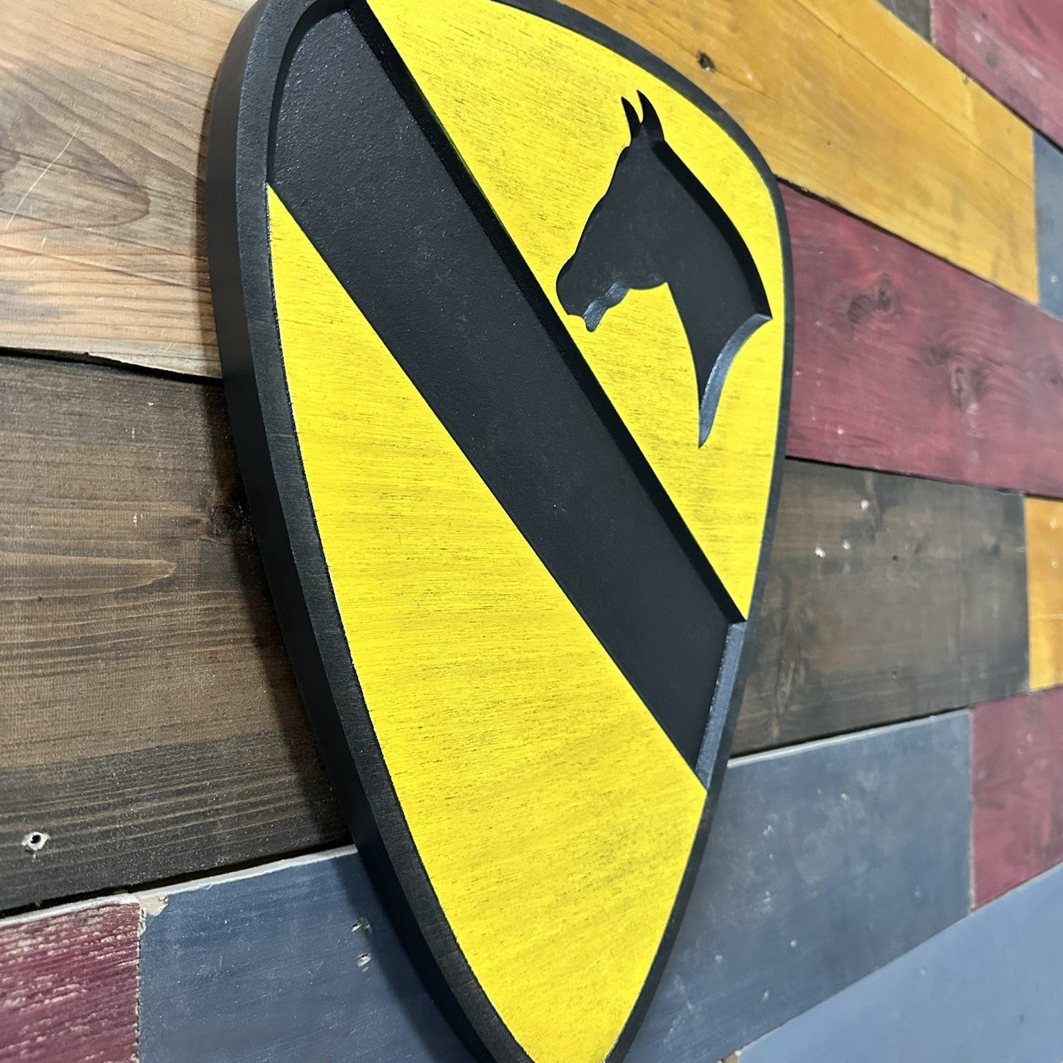 Close up detail of 1st Cavalry Division carved wood sign with black border showing dimensional depth and hand painted finish