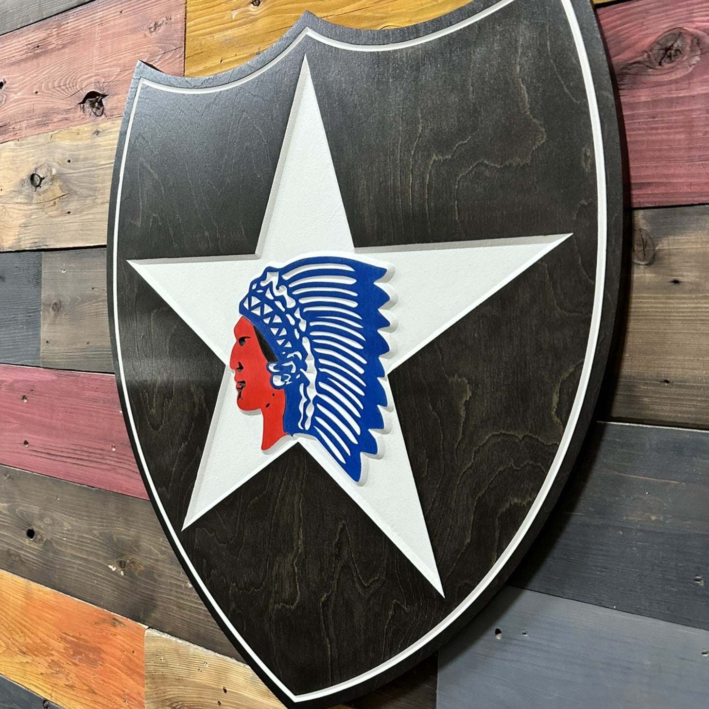 Close up detail of 2nd Infantry Division Indianhead carved wood sign showing layered star and center emblem