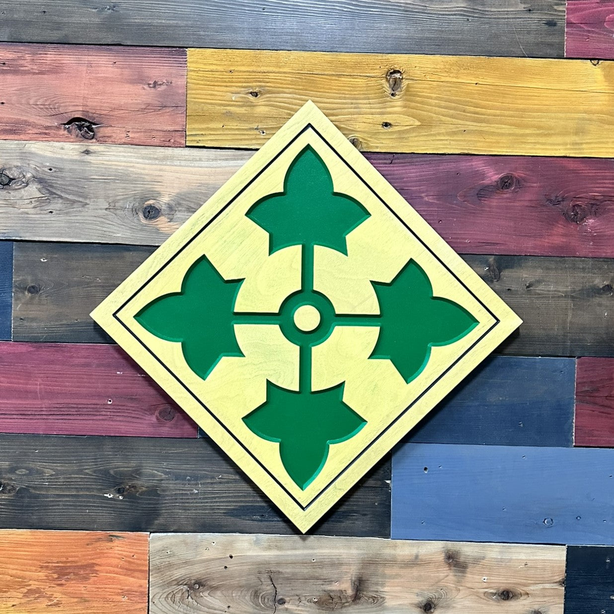Close up detail of 4th Infantry Division Ivy carved wood sign showing dimensional ivy cross