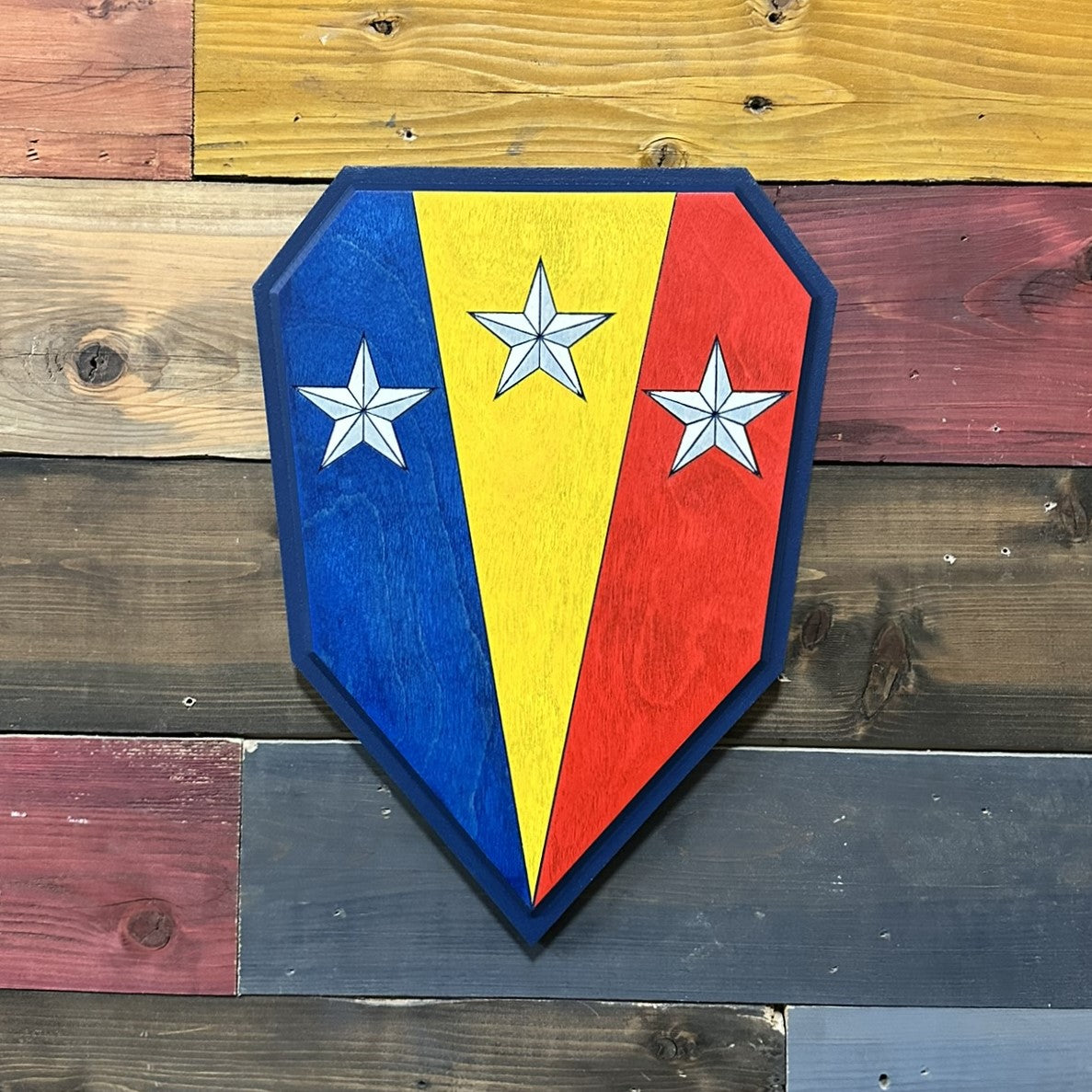 Close up detail of 50th Infantry Brigade Combat Team Combat Service Identification Badge carved wood sign showing raised star detail