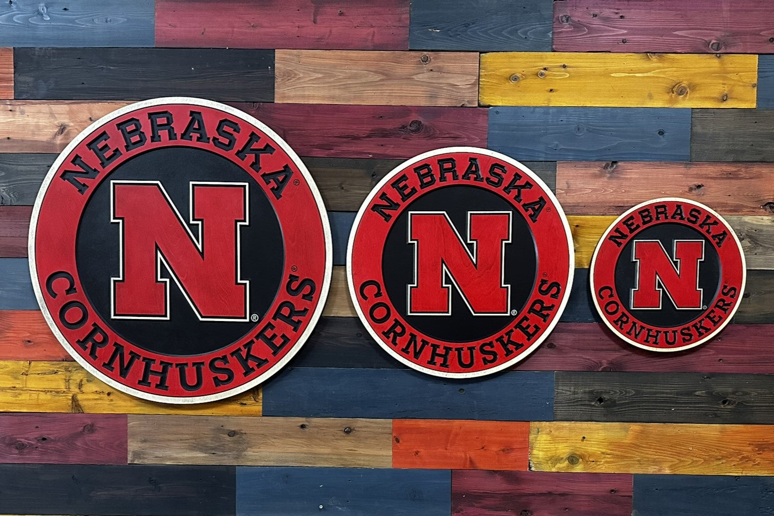 Nebraska Cornhuskers logo on a wooden background with various wood colors.