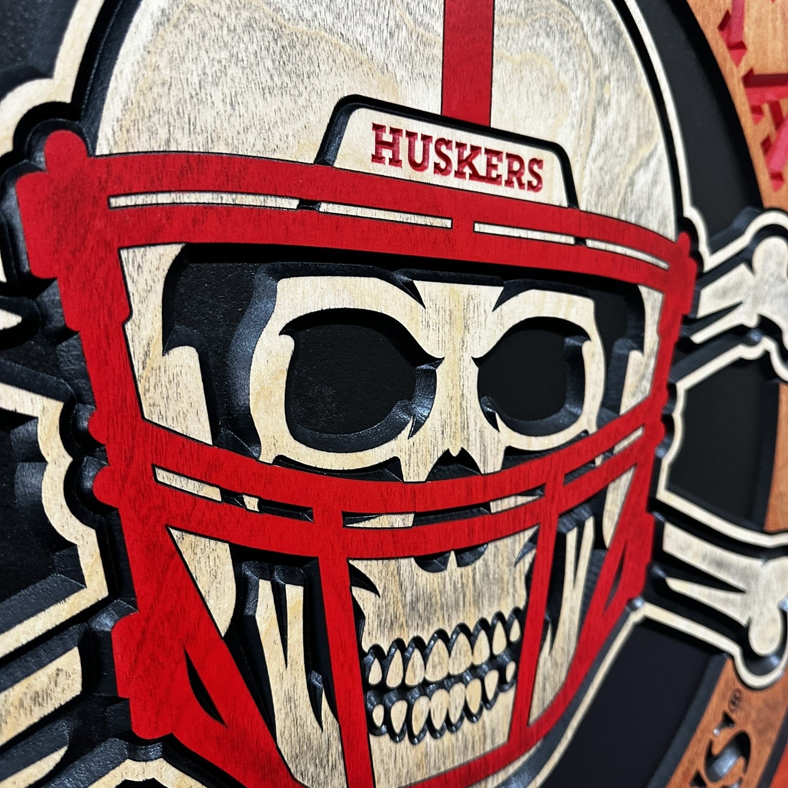 Skull wearing a red football helmet with 'HUSKERS' text on a black background