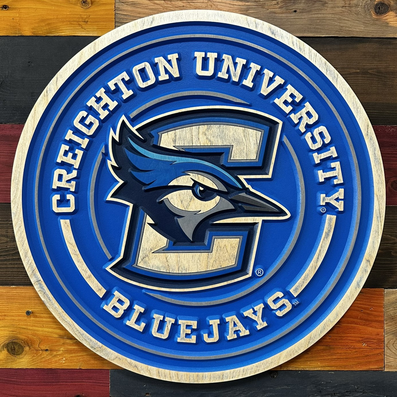 Close-up of carved Creighton Bluejays round full logo wood sign detail