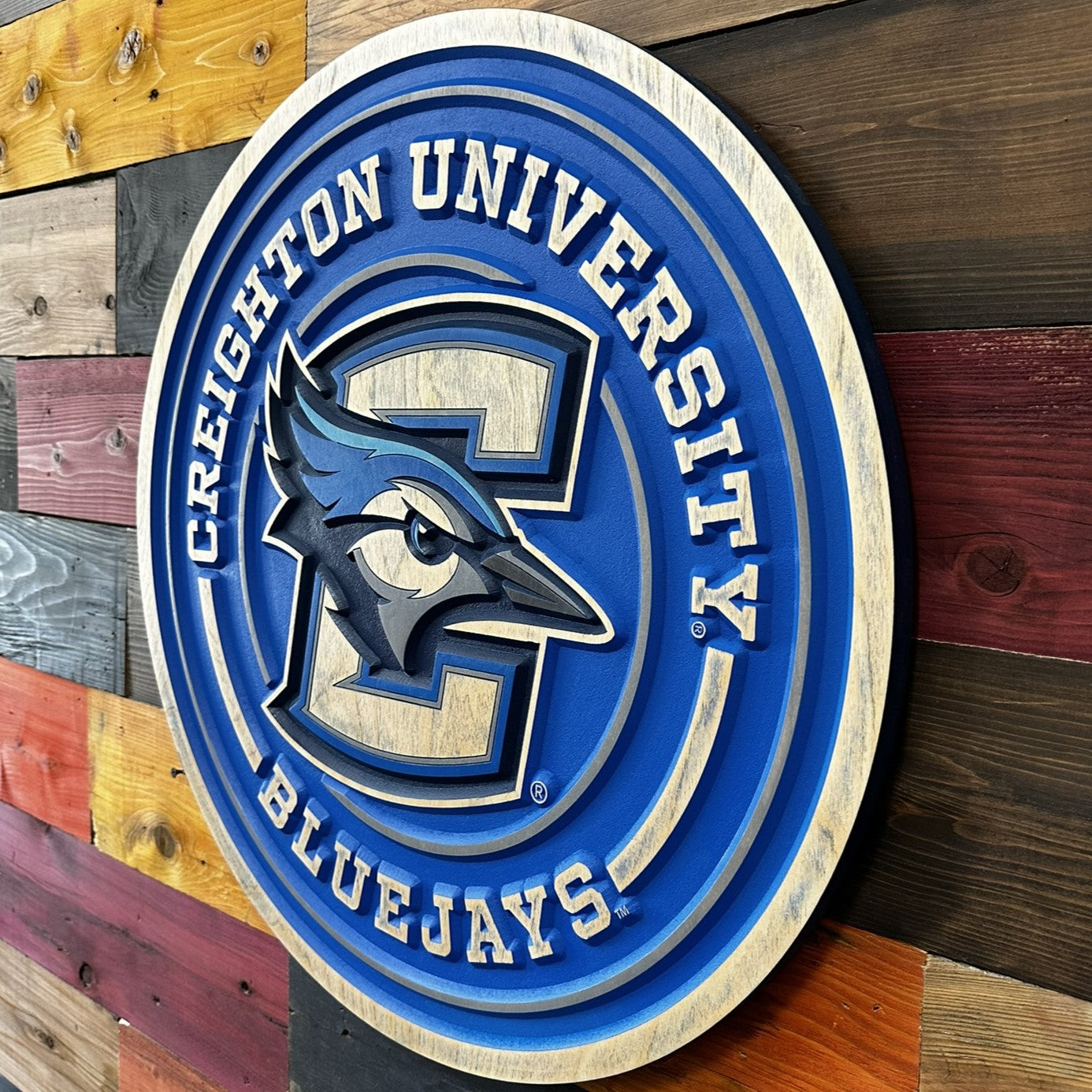 Side profile of Creighton Bluejays round full logo wood sign