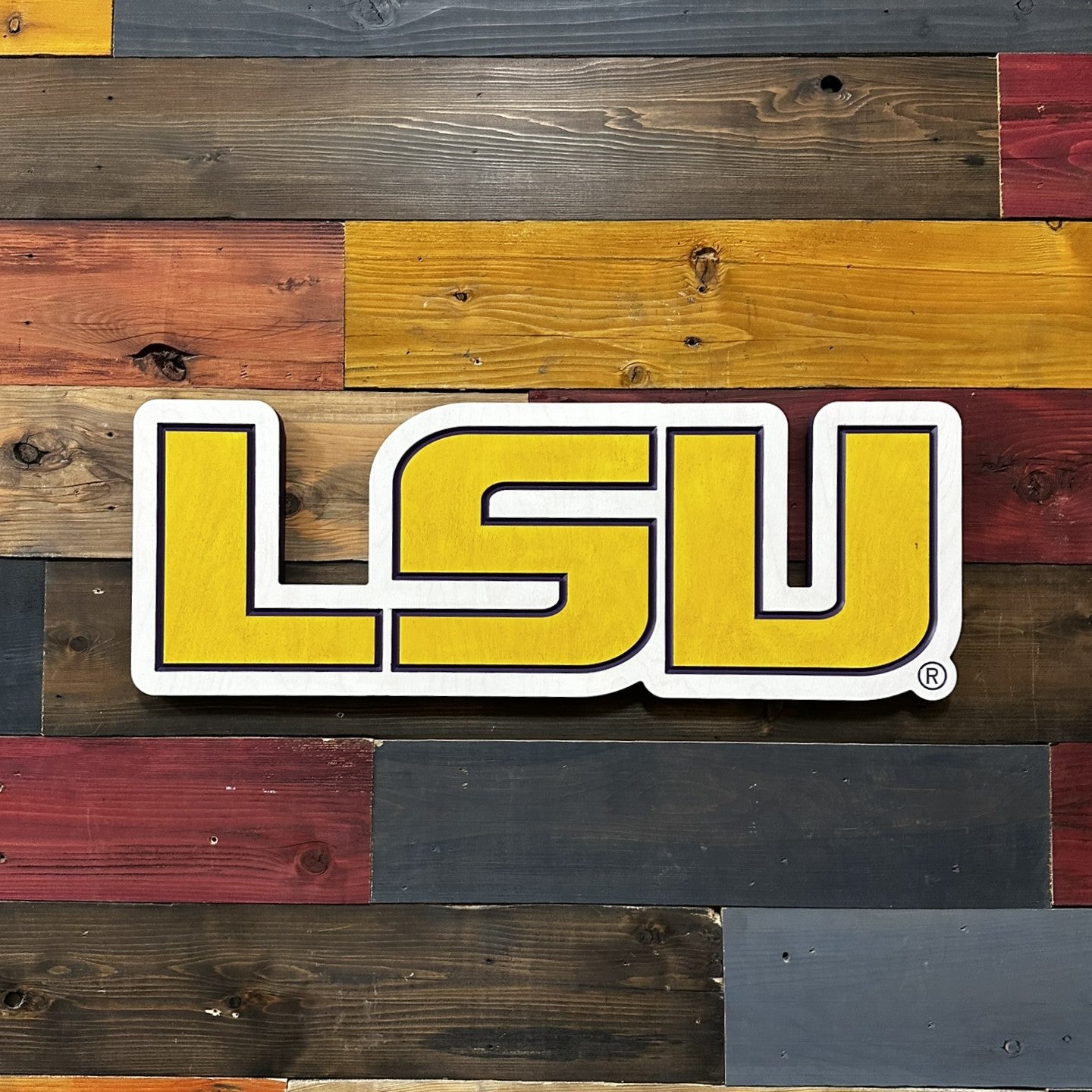 Angled front view of horizontal LSU wooden wall decor showing dimensional collegiate lettering and handcrafted carved detail