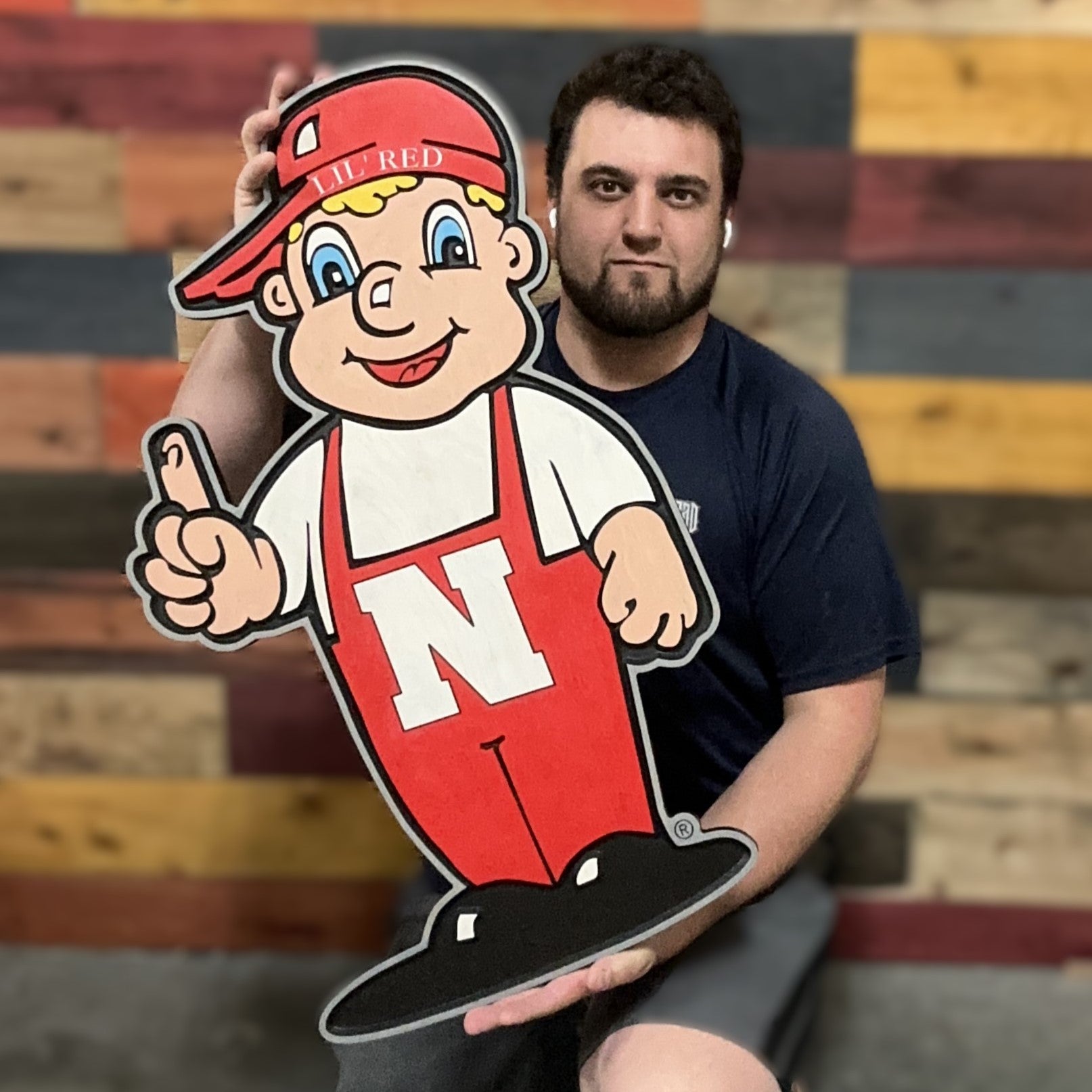 Huskers Little Red wood sign being held for size reference