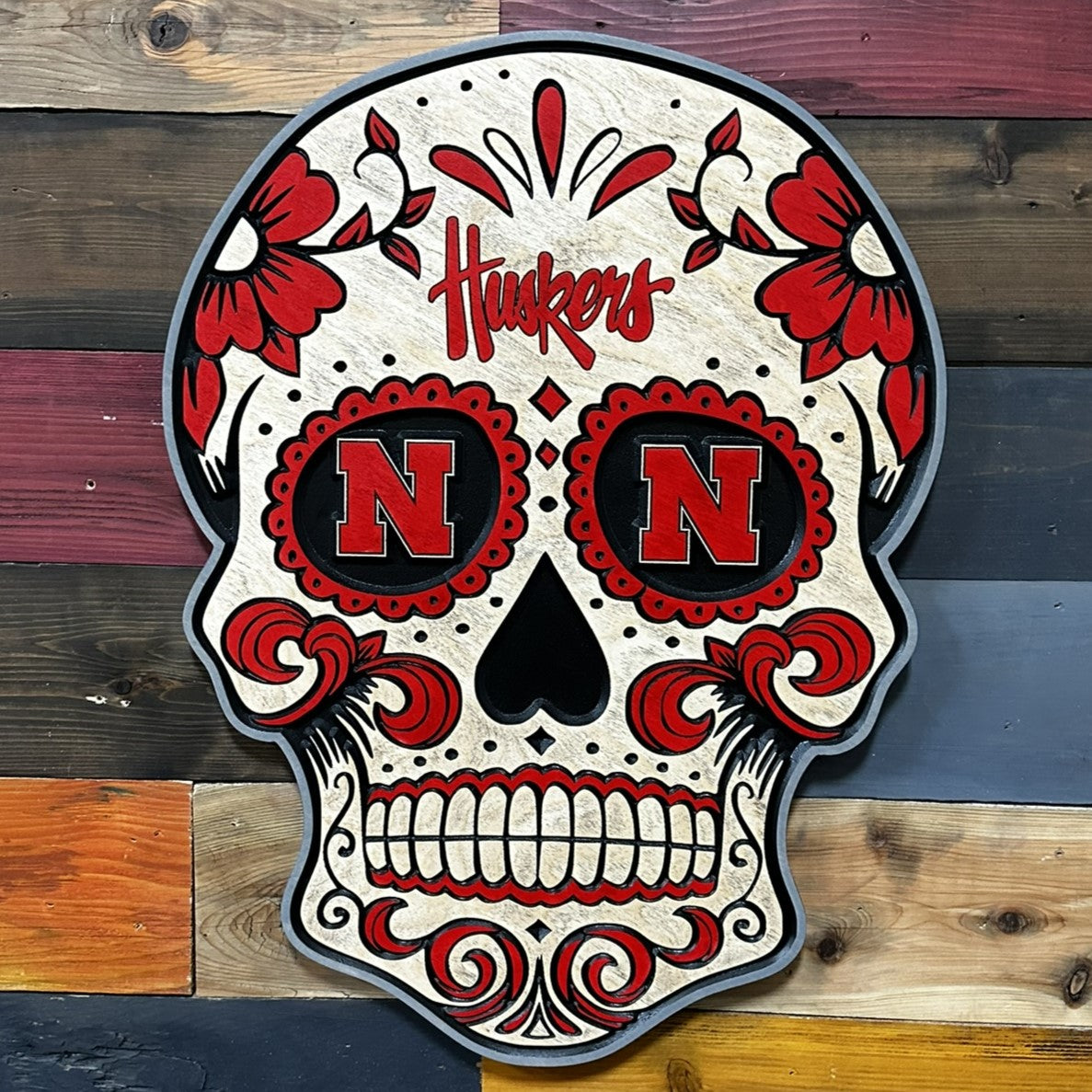 Close-up of carved Huskers sugar skull wood sign detail