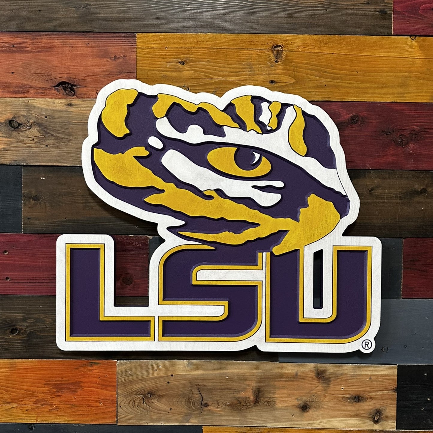 Angled front view of LSU Tiger Eye wooden wall decor featuring dimensional LSU lettering and bold carved mascot styling