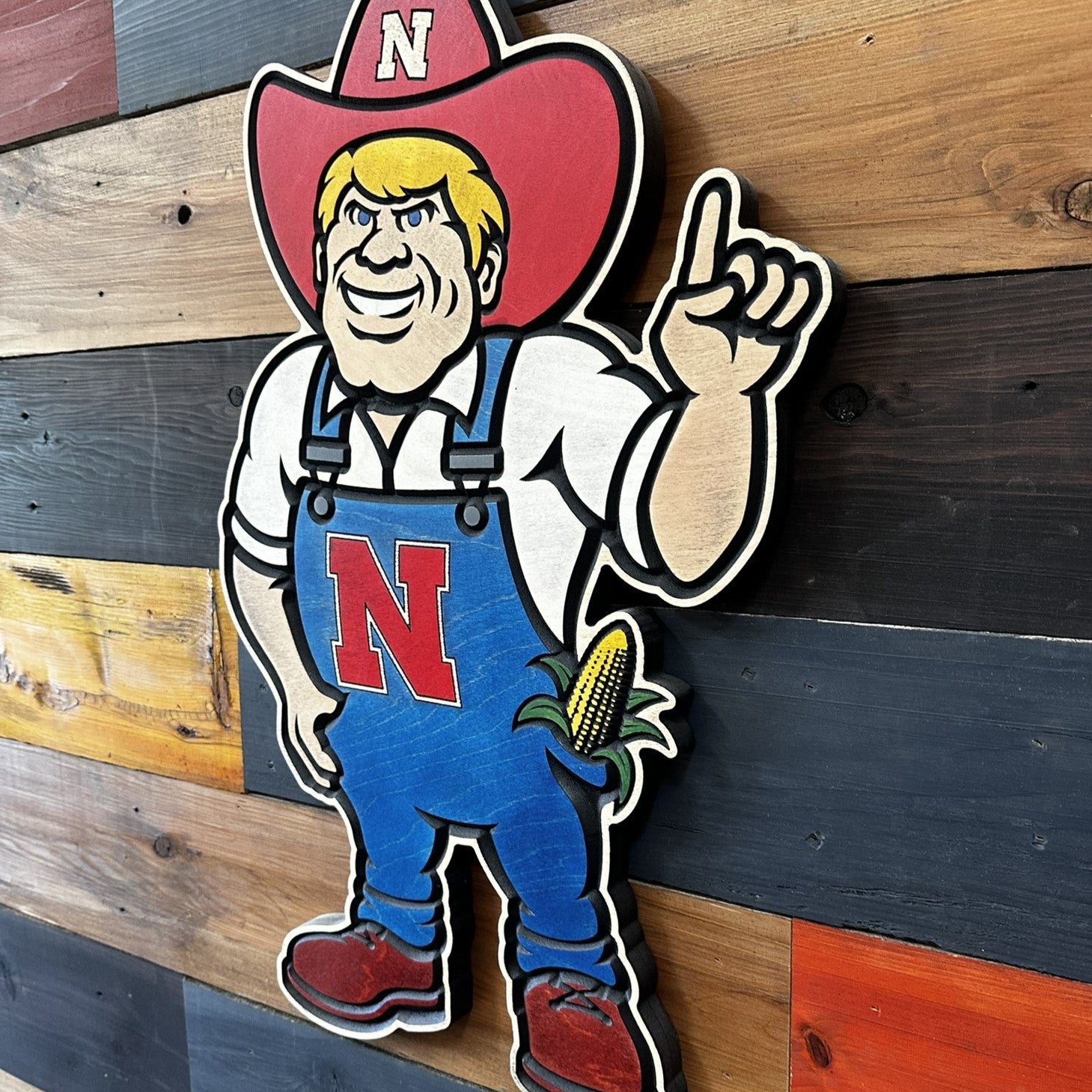 Angled view of Nebraska Cornhuskers Herbie Husker wood sign