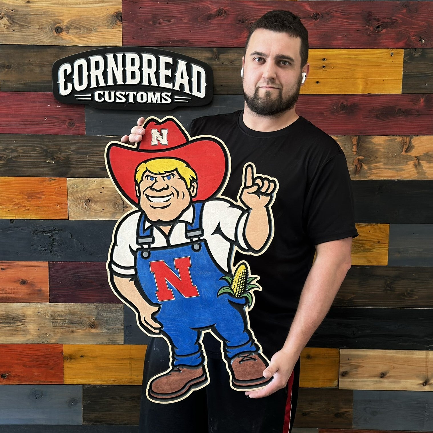 Herbie Husker wood sign being held for size reference