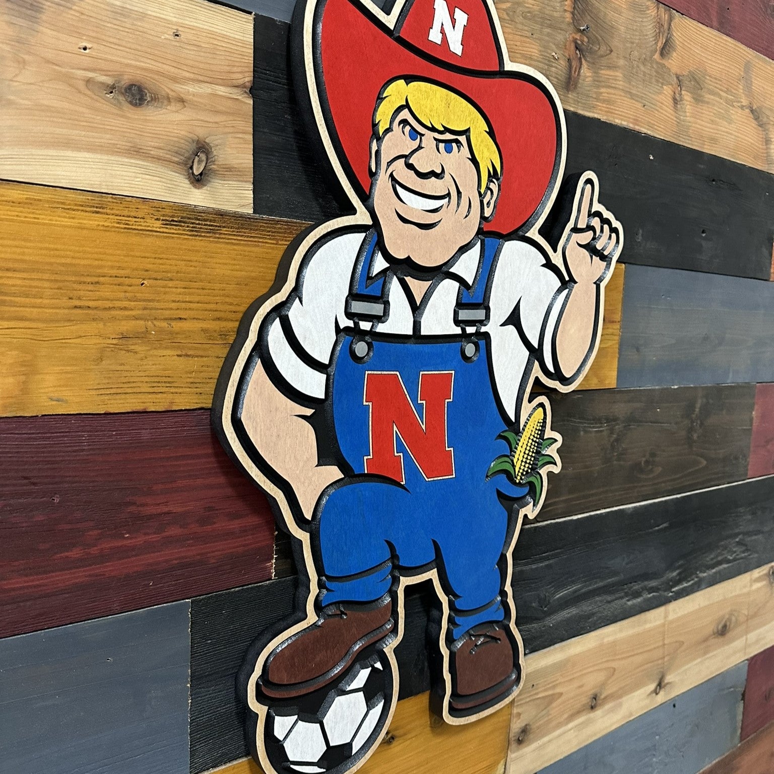 Close up of handcrafted Nebraska Herbie Husker soccer wood sign