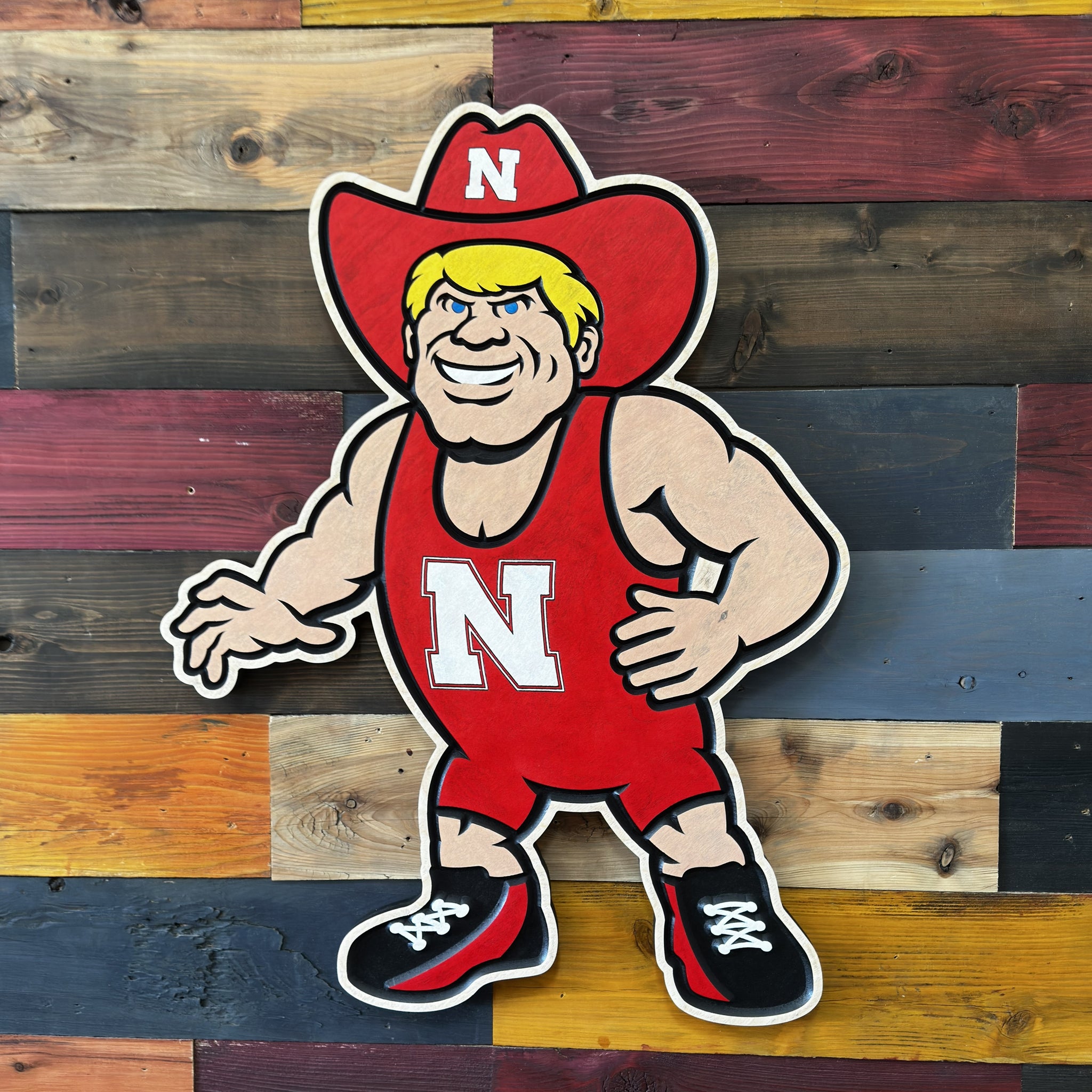 Close up of handcrafted Nebraska Herbie Husker wrestling wood sign