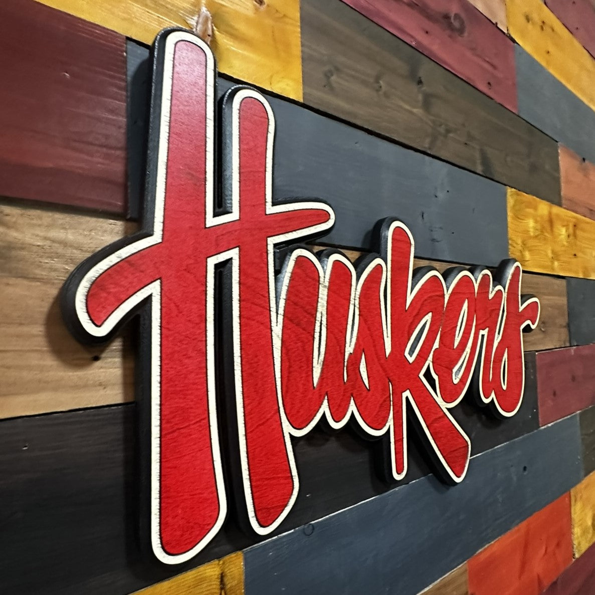 Angled view of Nebraska Huskers red script 3D wood sign
