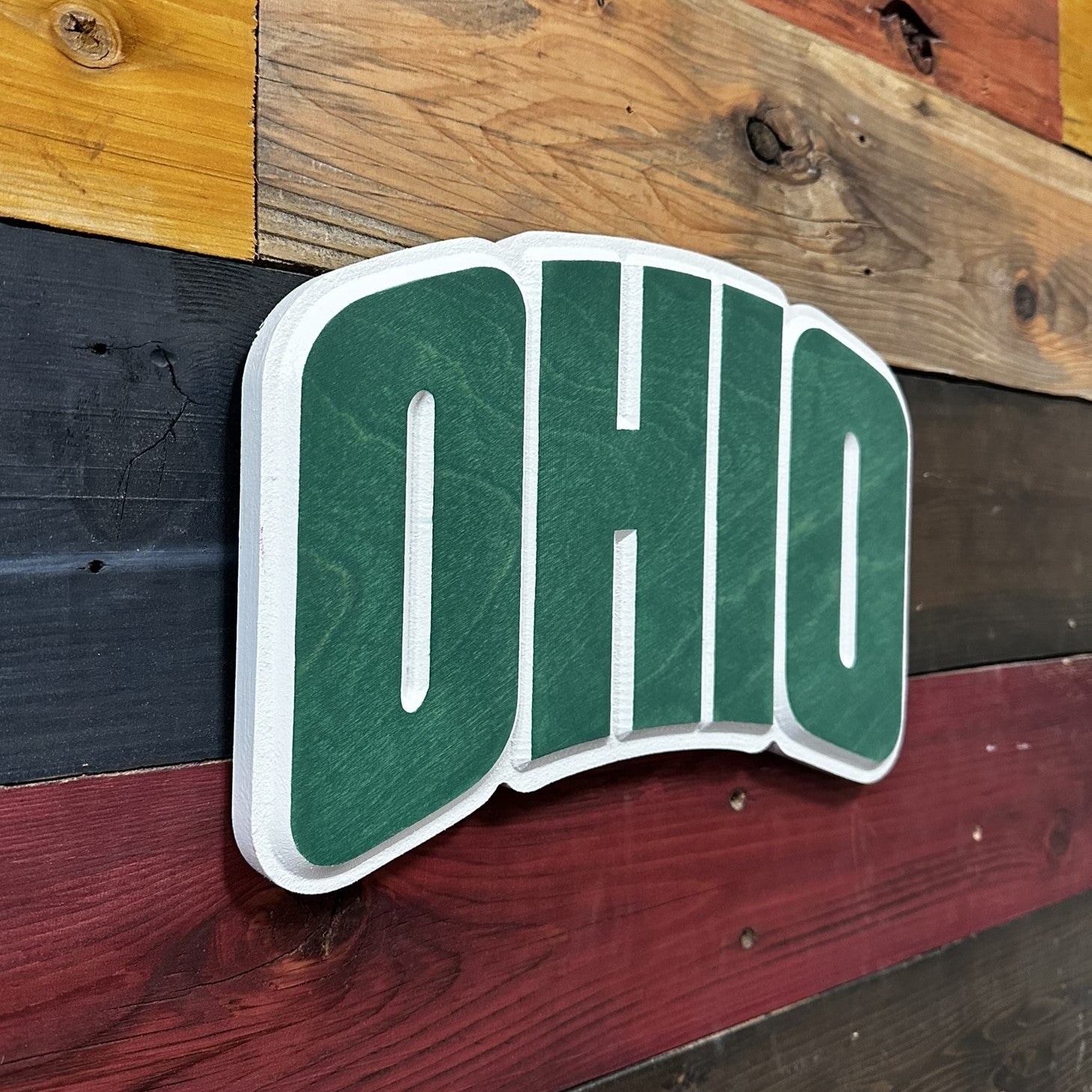 Close up detail of carved Ohio University Bobcats OHIO wood sign showing stained wood grain and dimensional carving