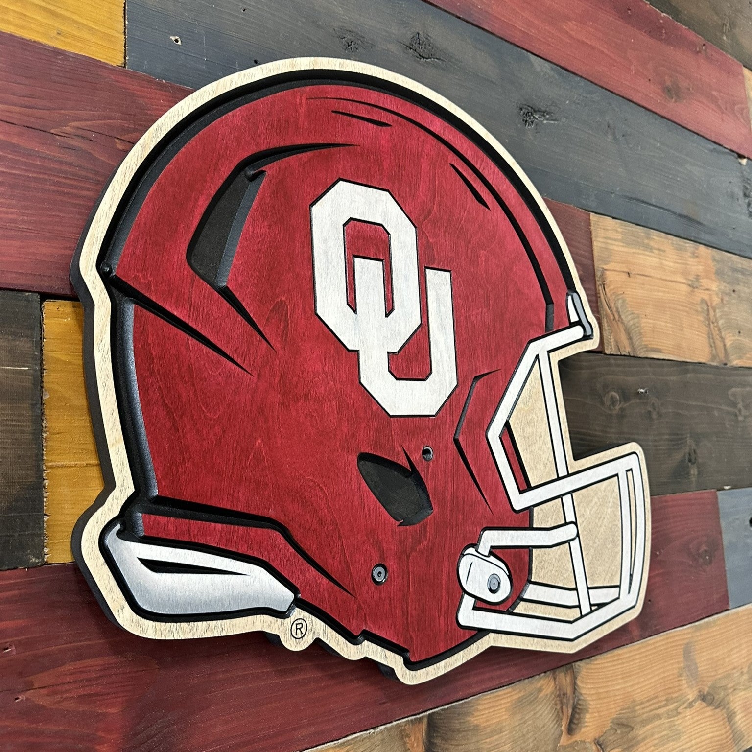 Officially licensed Oklahoma Sooners helmet wood sign displayed as football wall décor in a home or man cave.