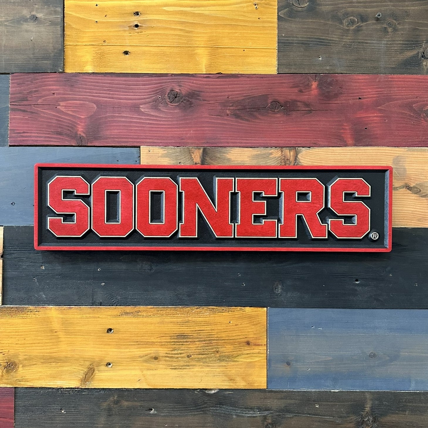 Oklahoma Sooners handcrafted wood wall sign displayed on a rustic wood wall
