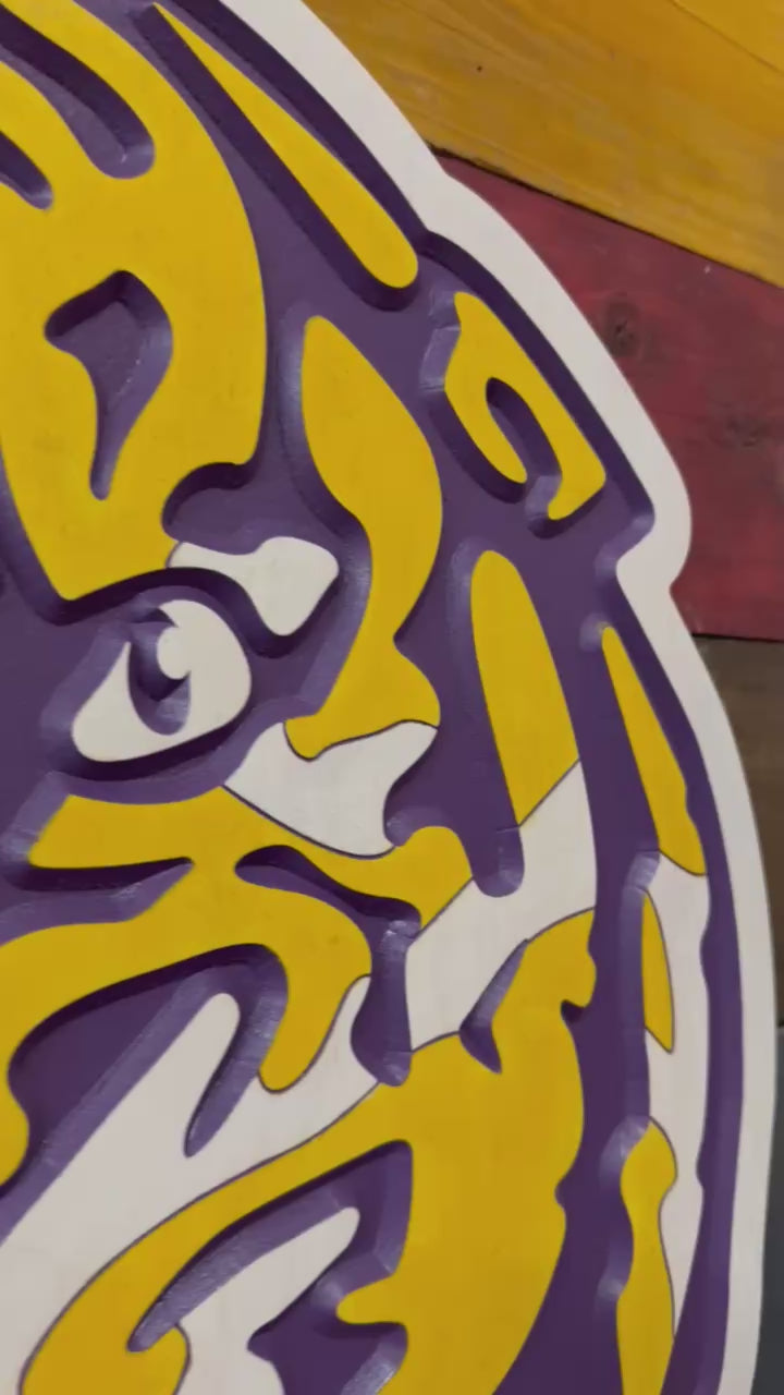 Video showcasing dimensional carving depth and handcrafted LSU Fighting Tiger Head artwork with layered purple and gold detail