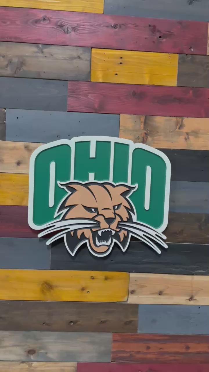 Video showcasing layered carving depth and handcrafted Rufus the Bobcat mascot detail on an Ohio University wood wall sign