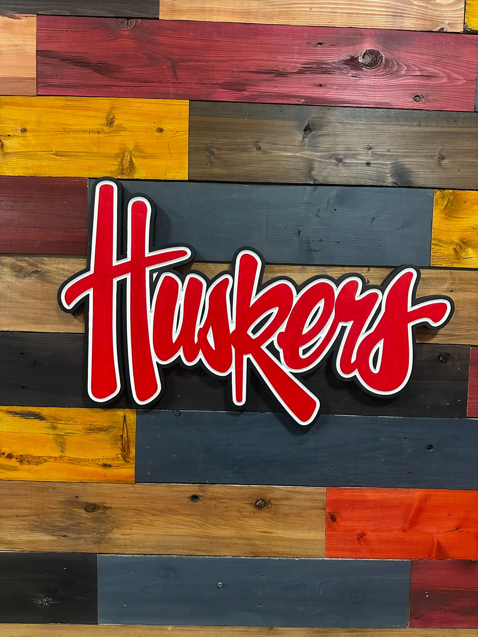 Video of Nebraska Huskers red script 3D wood sign with black wood-stain border