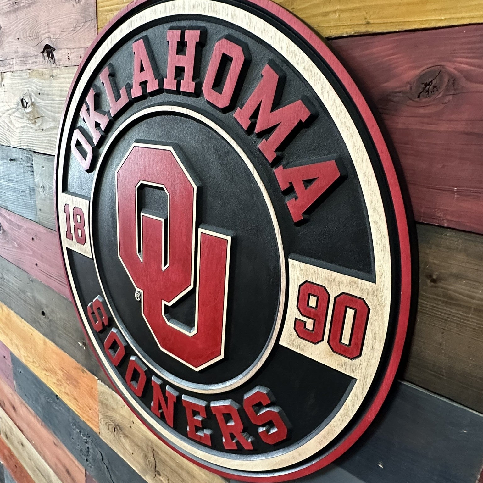 Take a closer look at our officially licensed Oklahoma Sooners 1890 Round Wood Sign. Precision CNC carved, hand-painted, and handcrafted in Nebraska, this premium OU wall art celebrates the rich tradition of Oklahoma athletics and makes a perfect addition to any fan cave, office, or game room.