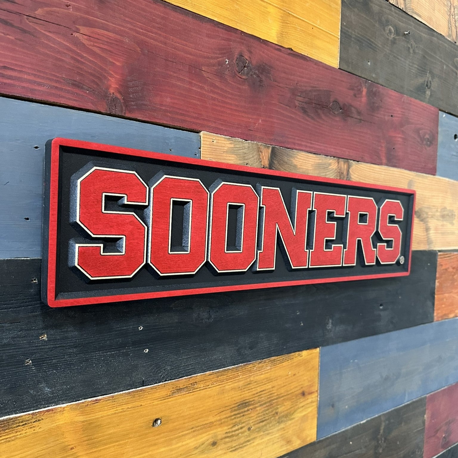 Close angle of Oklahoma Sooners crimson and black wood sign