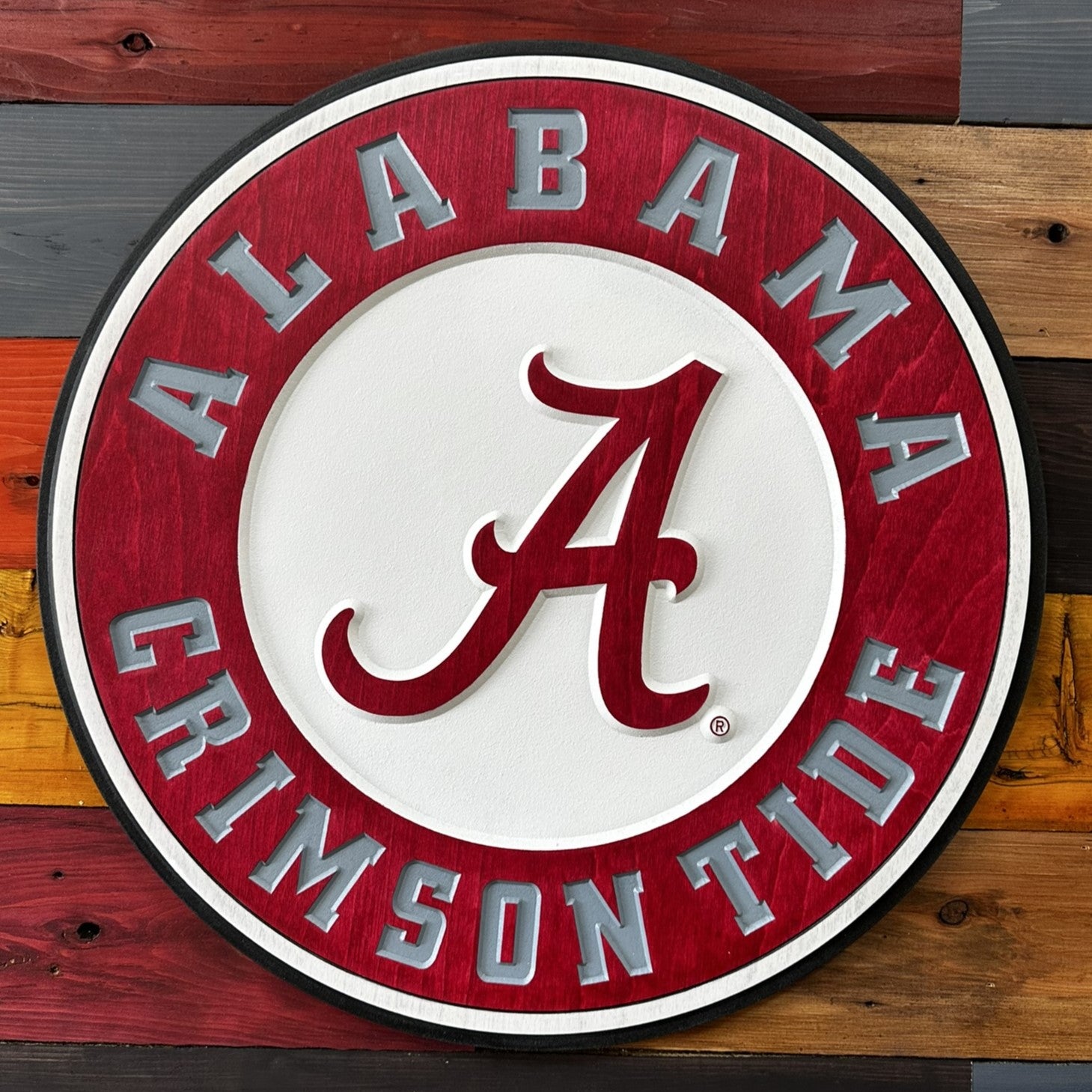 Close-up of carved University of Alabama round wood sign detail