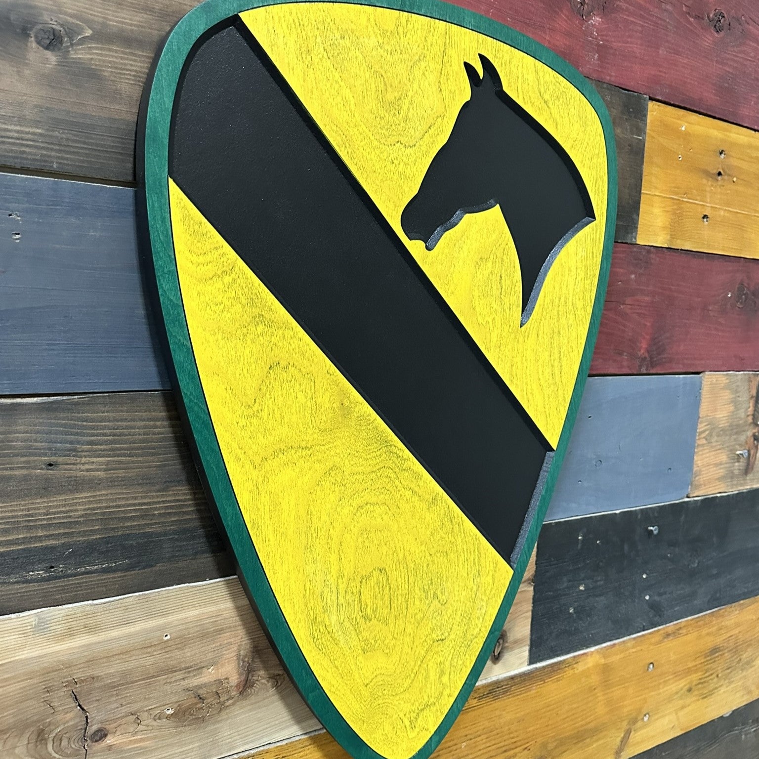 Side profile of US Army 1st Cavalry Division carved wood wall sign with green border showing carved thickness