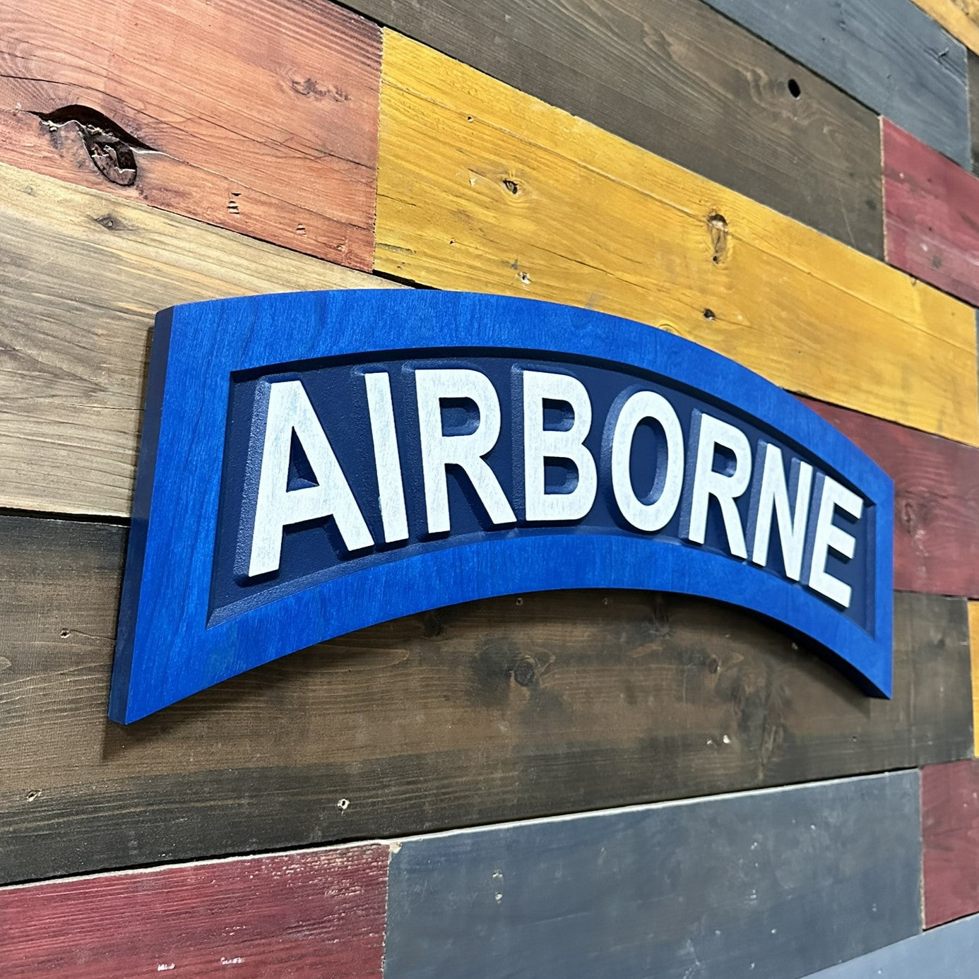Side profile of US Army Airborne tab navy blue carved wood wall sign showing thickness