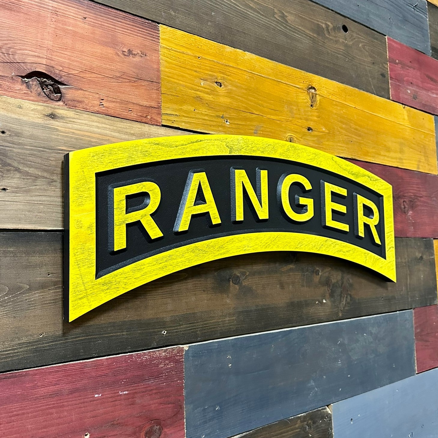 Close up detail of US Army Ranger tab carved wood wall sign showing raised RANGER lettering
