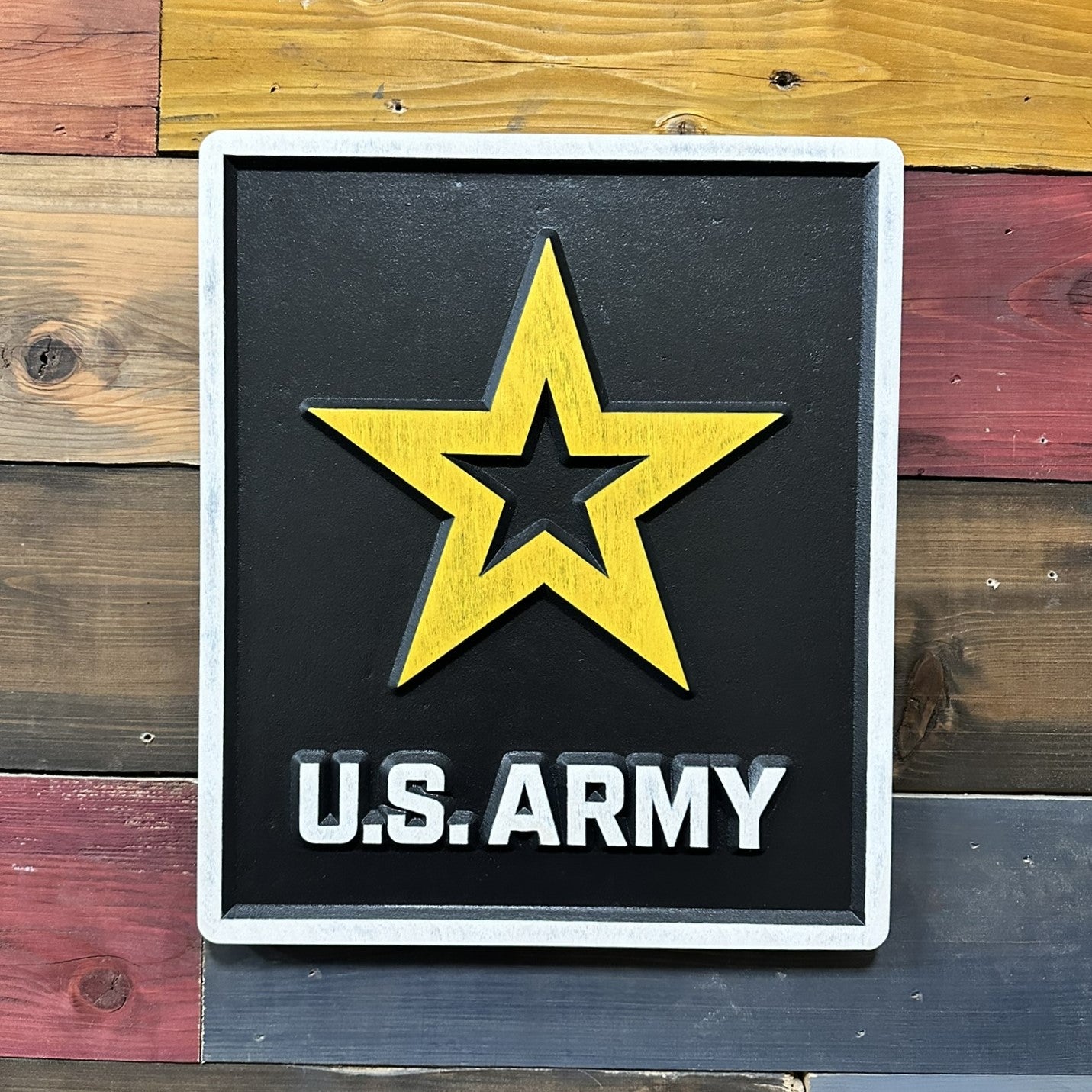 Close up detail of raised yellow U.S. Army star on carved wood wall sign